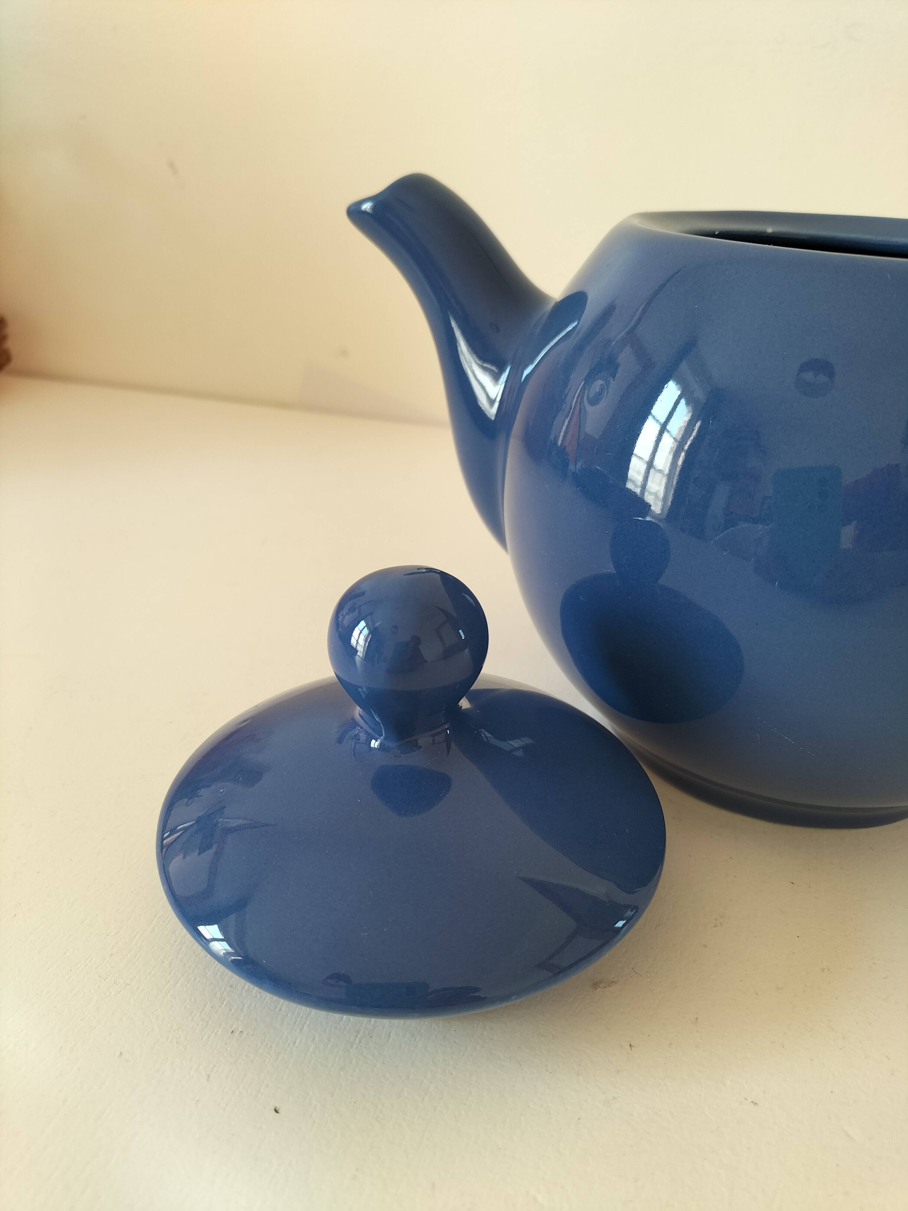 Vintage deep blue teapot, minimalist round shape.