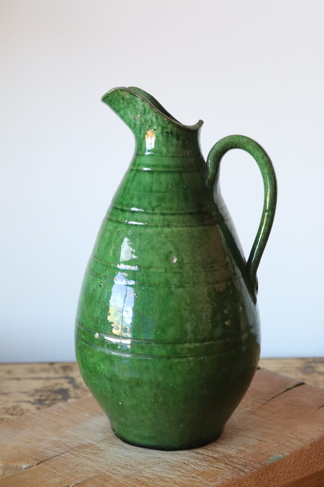 Green old pitcher in glazed terracotta