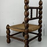 Brutalist wood turned bobbin low rush chair in the style of Charles Dudouyt