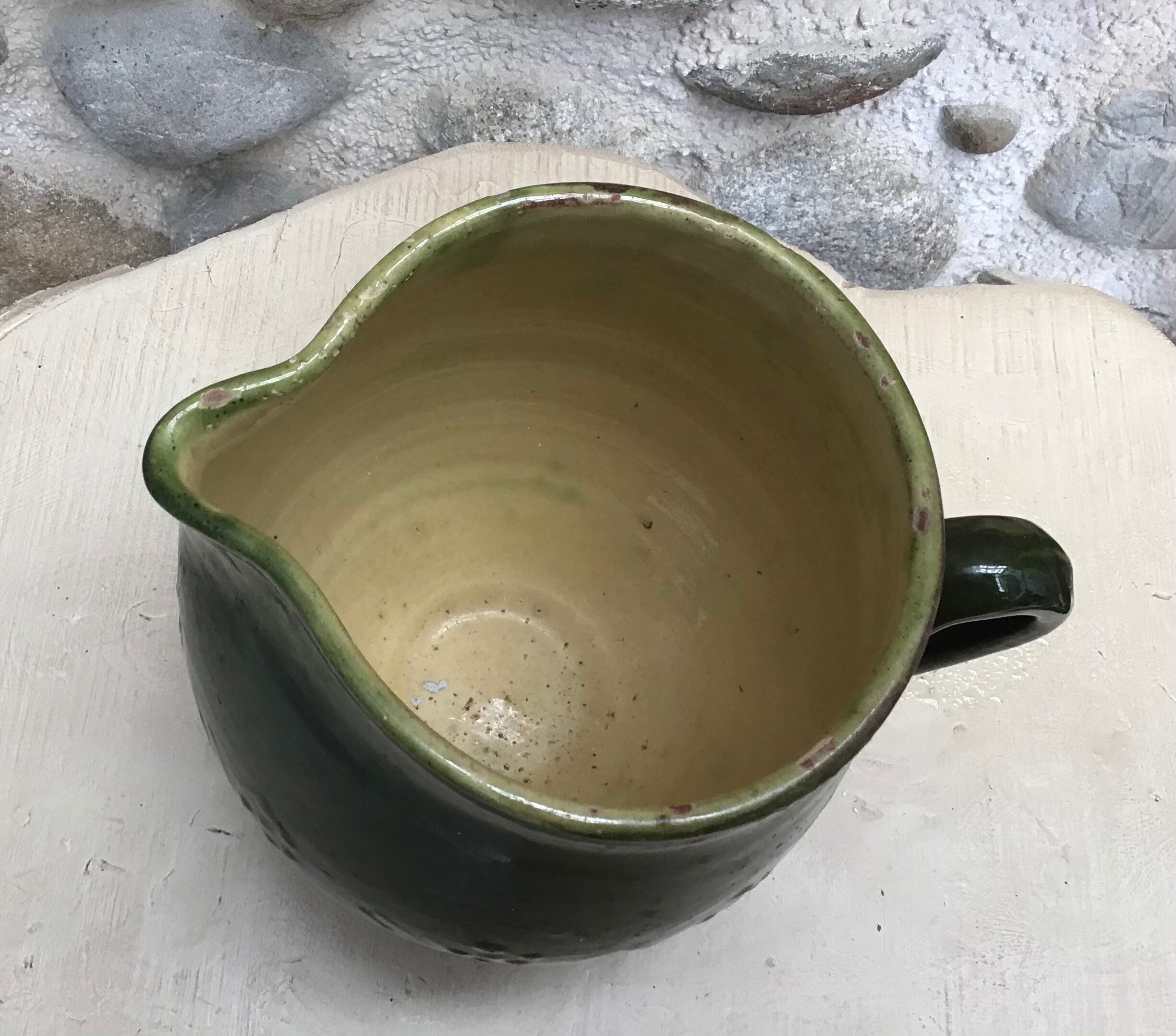 Green varnished earth pitcher with flower pattern