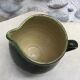 Green varnished earth pitcher with flower pattern