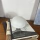 Small antique ceiling light or wall sconce with a frosted white glass half-moon.