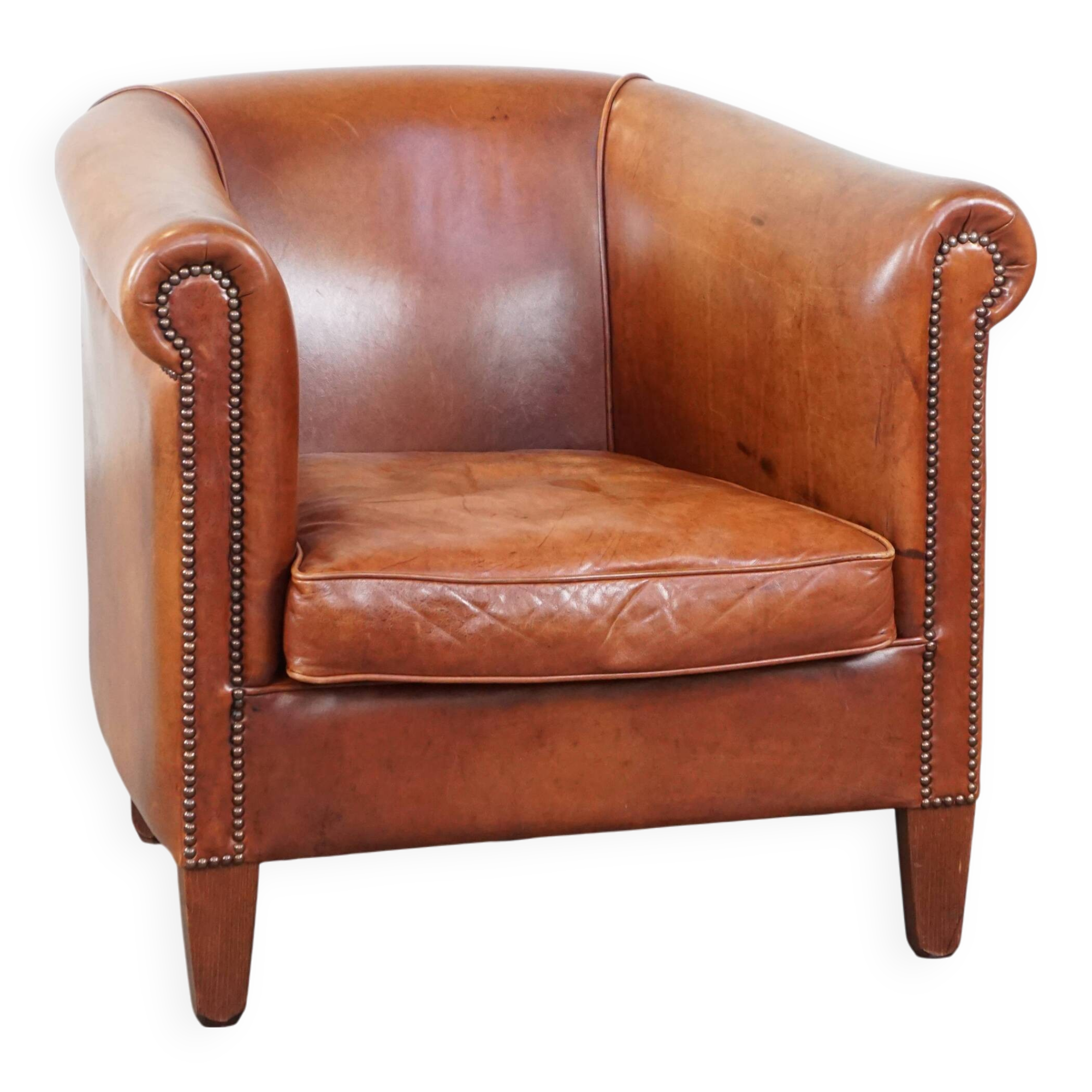 Cognac-colored cow leather club chair finished with decorative nails in English style