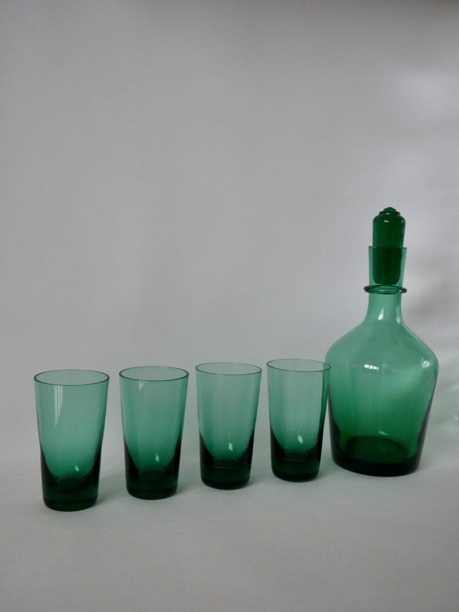 Set of a carafe and 4 designer glasses in green glass from the 70s