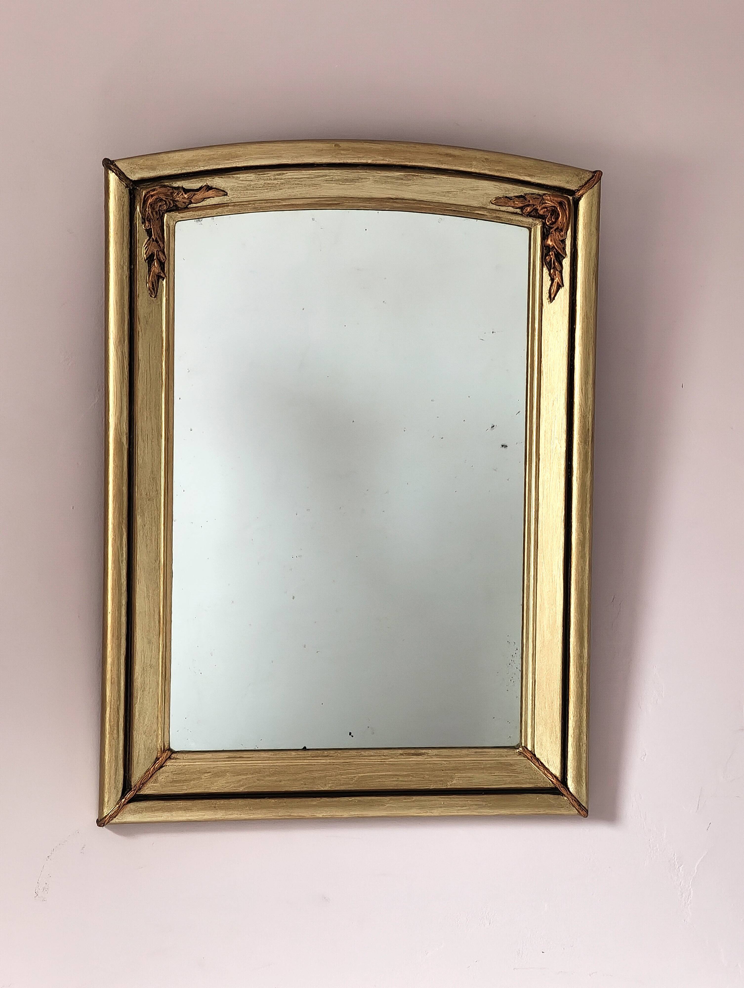 Art Deco mirror in gilded wood with curved floral decorations.