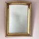 Art Deco mirror in gilded wood with curved floral decorations.