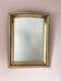 Art Deco mirror in gilded wood with curved floral decorations.