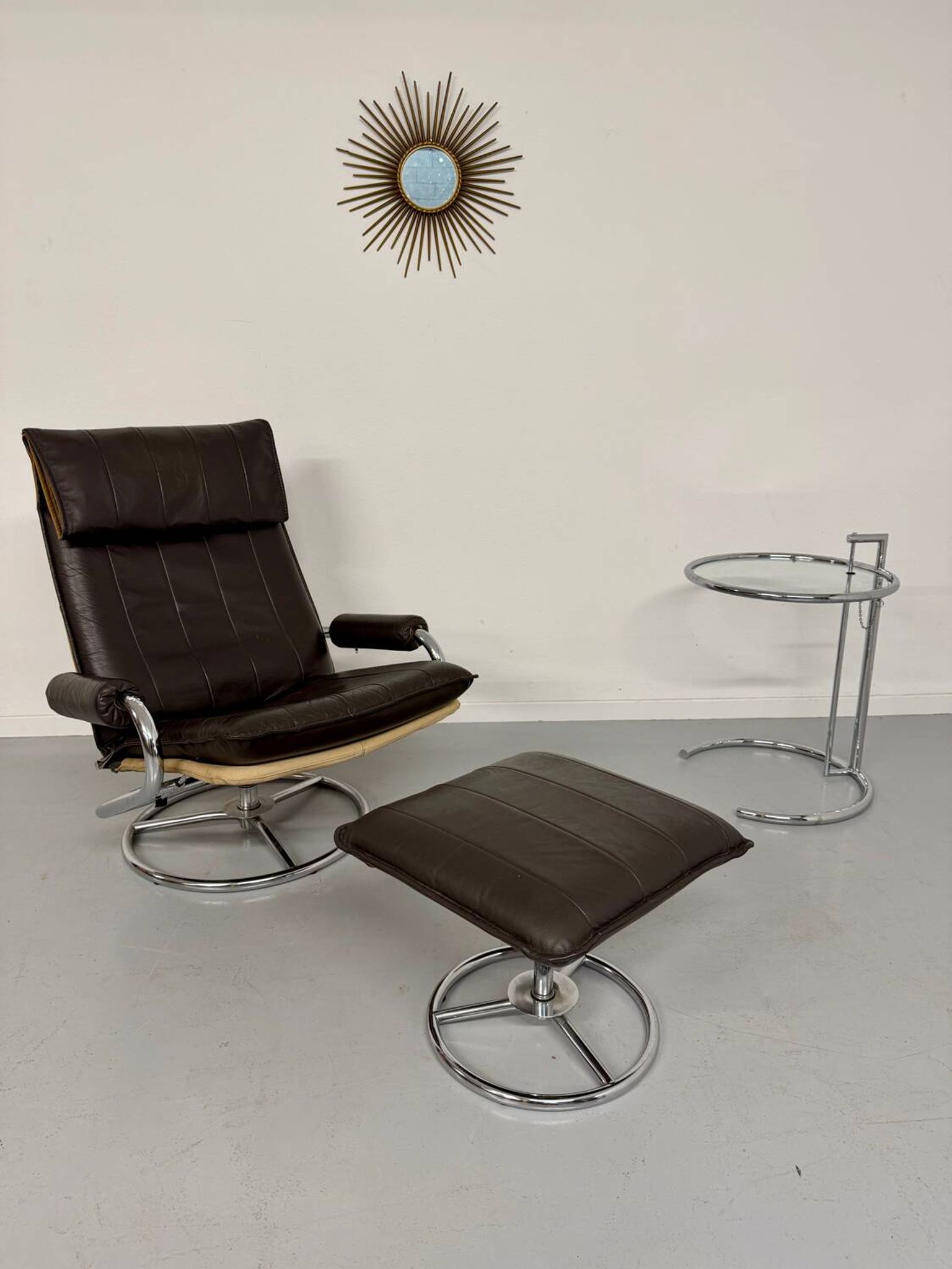 Vintage leather reclining armchair and its 1970s designer ottoman.