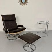 Vintage leather reclining armchair and its 1970s designer ottoman.