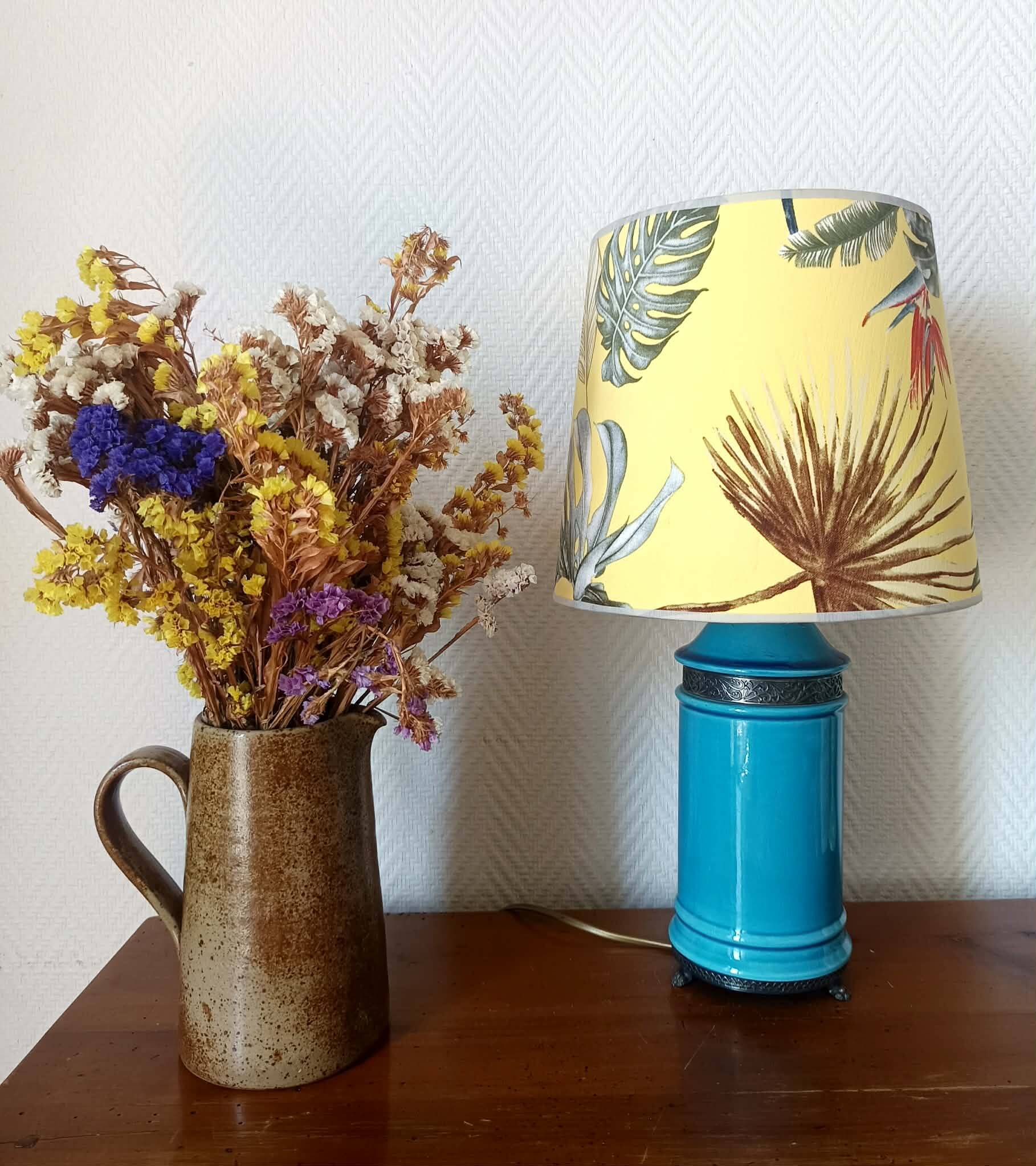 Blue ceramic lamp with claw feet and foliage lampshade.