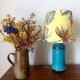 Blue ceramic lamp with claw feet and foliage lampshade.