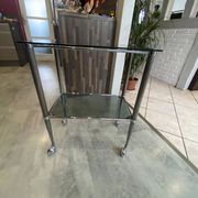 Serving dessert trolley with 2 smoked glass shelves and metal structure.