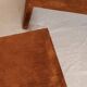 Pair of cognac suede side tables in the style of Jean Michel Frank.