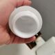 Old bathroom lamp with brown/golden ceramic base, porcelain socket and milky white glass