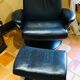 Black leather armchair stressless model jazz and its footrest