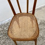 19th-century bistro chair, signed, with caned seat.