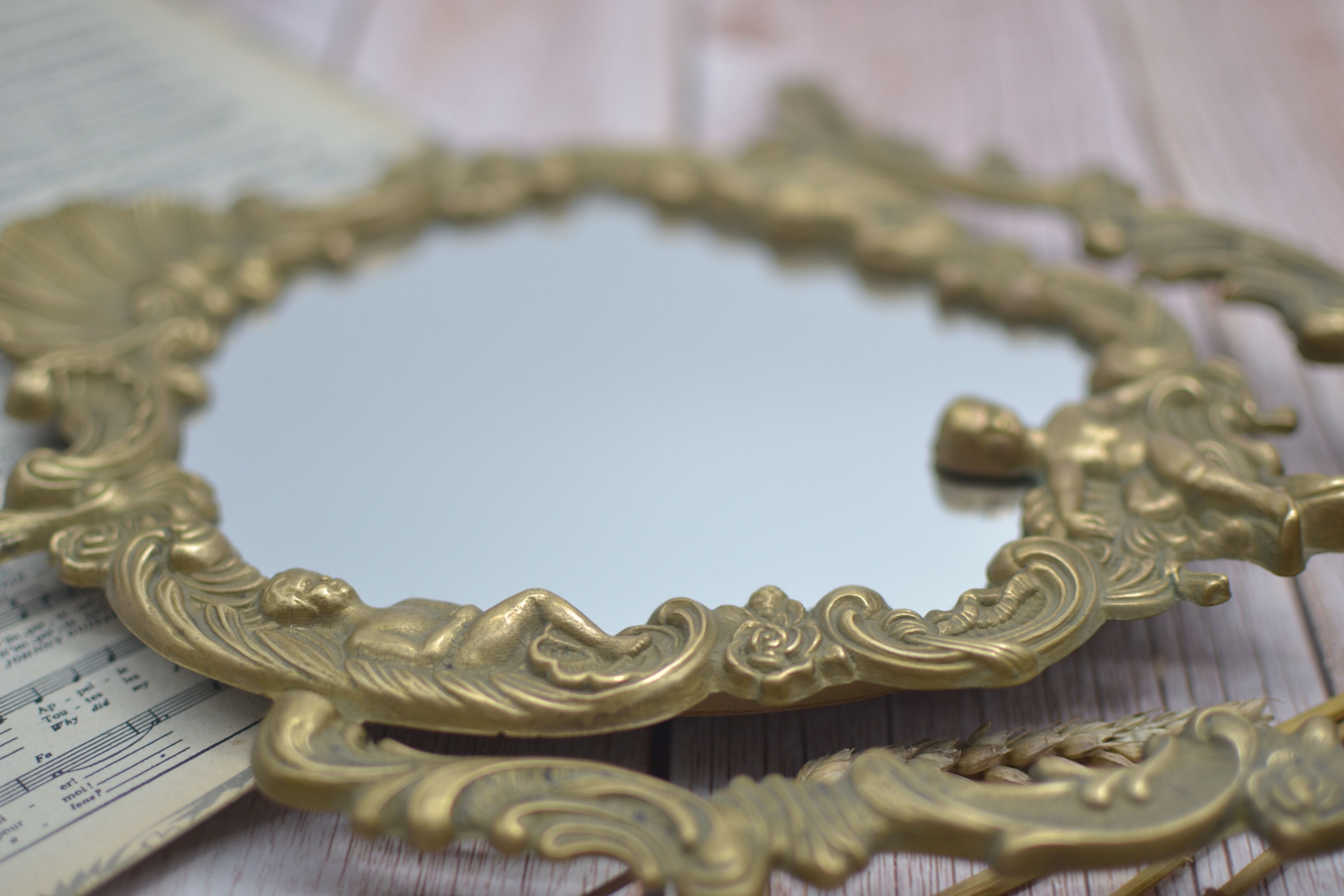 Adjustable psyche mirror of 33 centimeters in gilded bronze with angel ornament