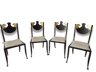 Ensemble de quatre chaises à décoration de têtes de rapace sur le dossier et fil doré en périphérie des montants et de l'assise