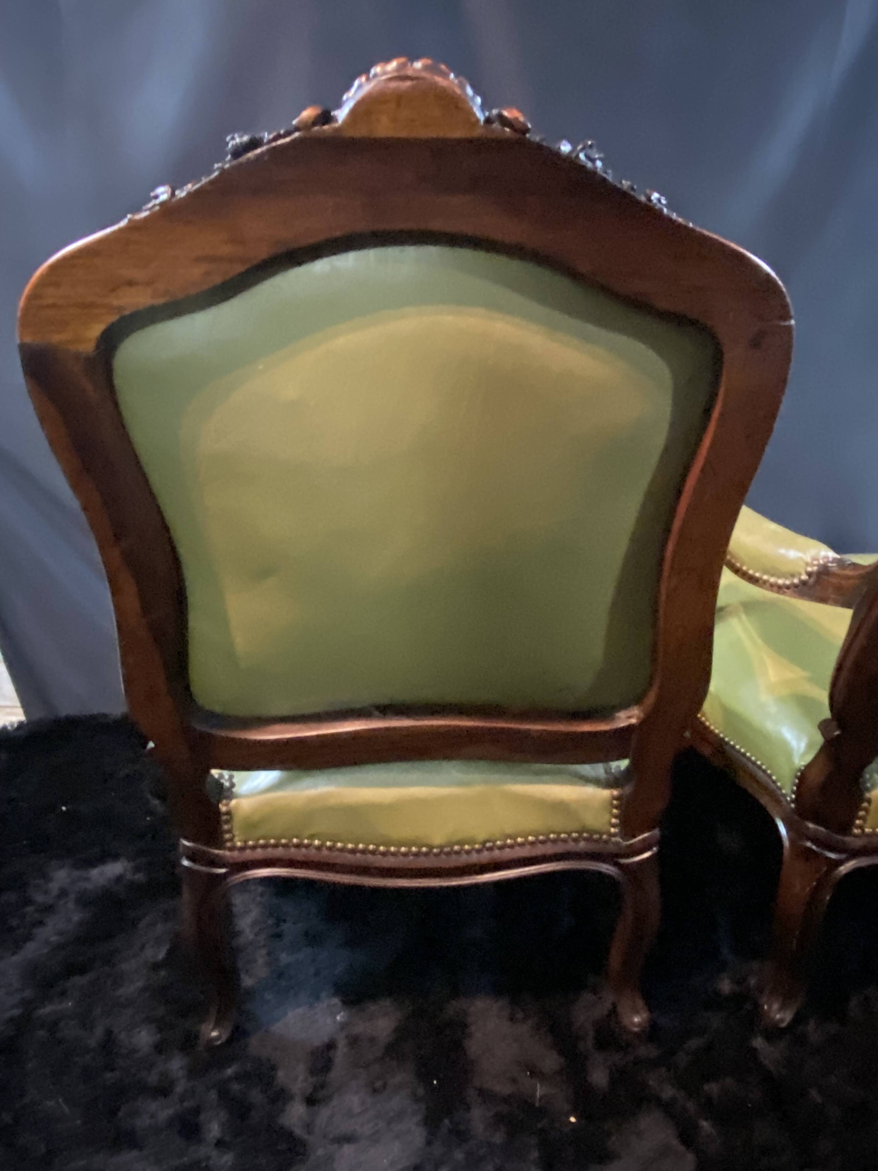 Paire de larges fauteuils XIXe en cuir vert de style Louis XV