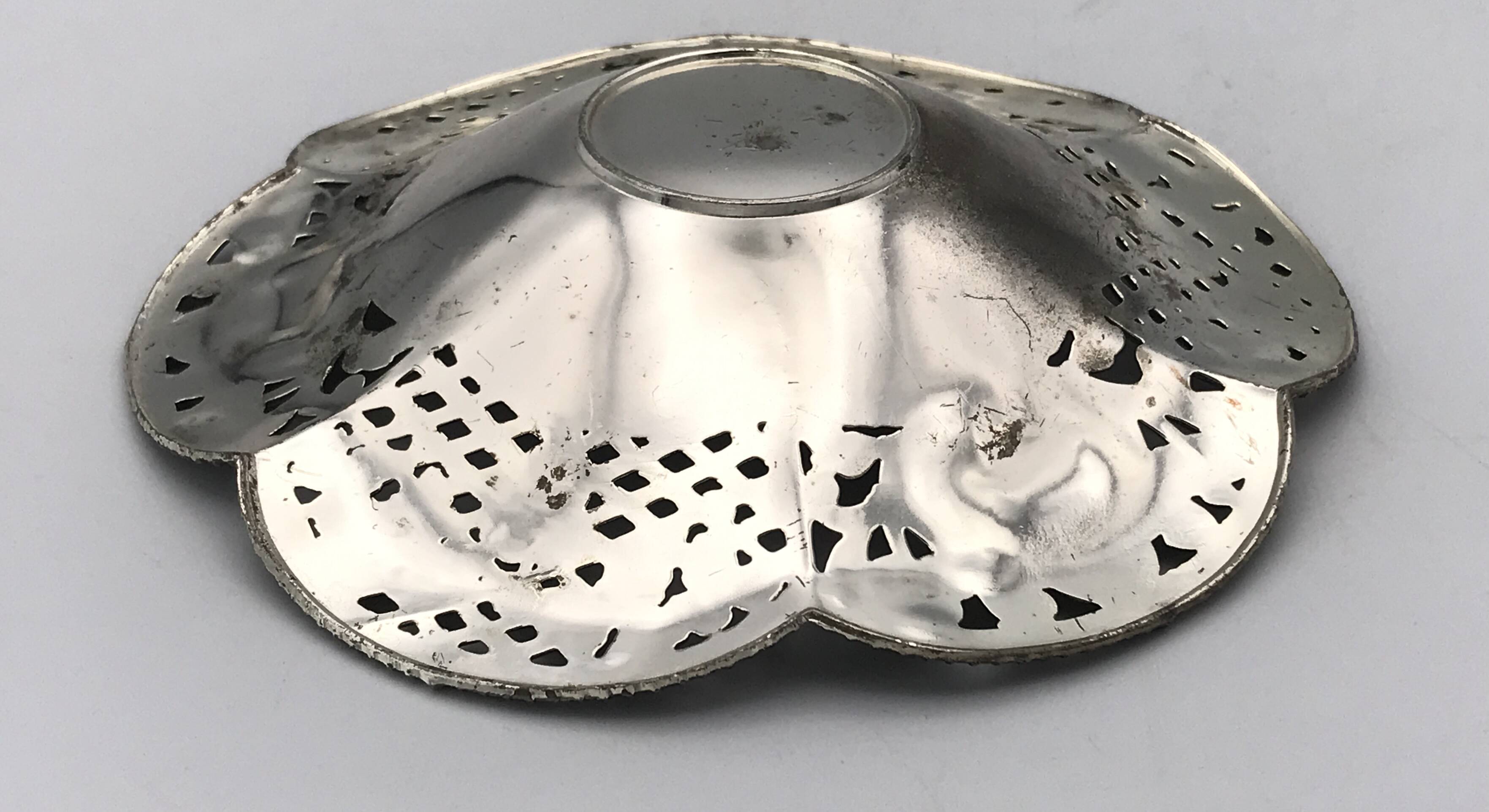 Silver-plated metal pocket emptier with openwork outline decoration