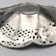 Silver-plated metal pocket emptier with openwork outline decoration
