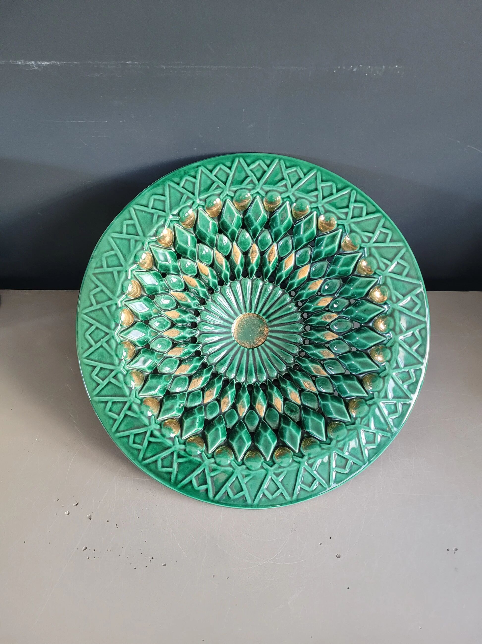 Large pierced earthenware fruit bowl glazed in green and gold.