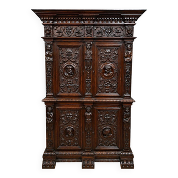 Ornate cabinet in richly carved wood in the Renaissance style.
