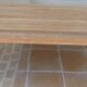 Large natural wood table with rectangular top supported by legs