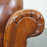 Fauteuil ancien en cuir de mouton couleur cognac