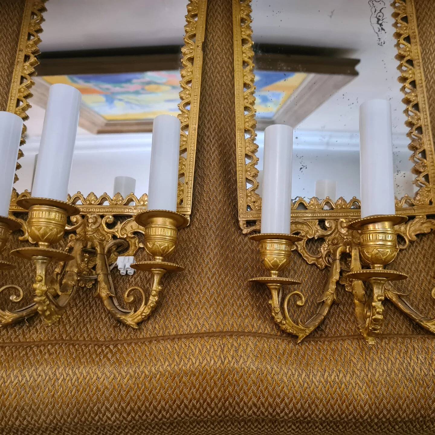 Pair of wall lights with mirror backgrounds with 3 arms of lights in chiseled and gilded bronze. framing decorated with foliage and masks. louis xiv style