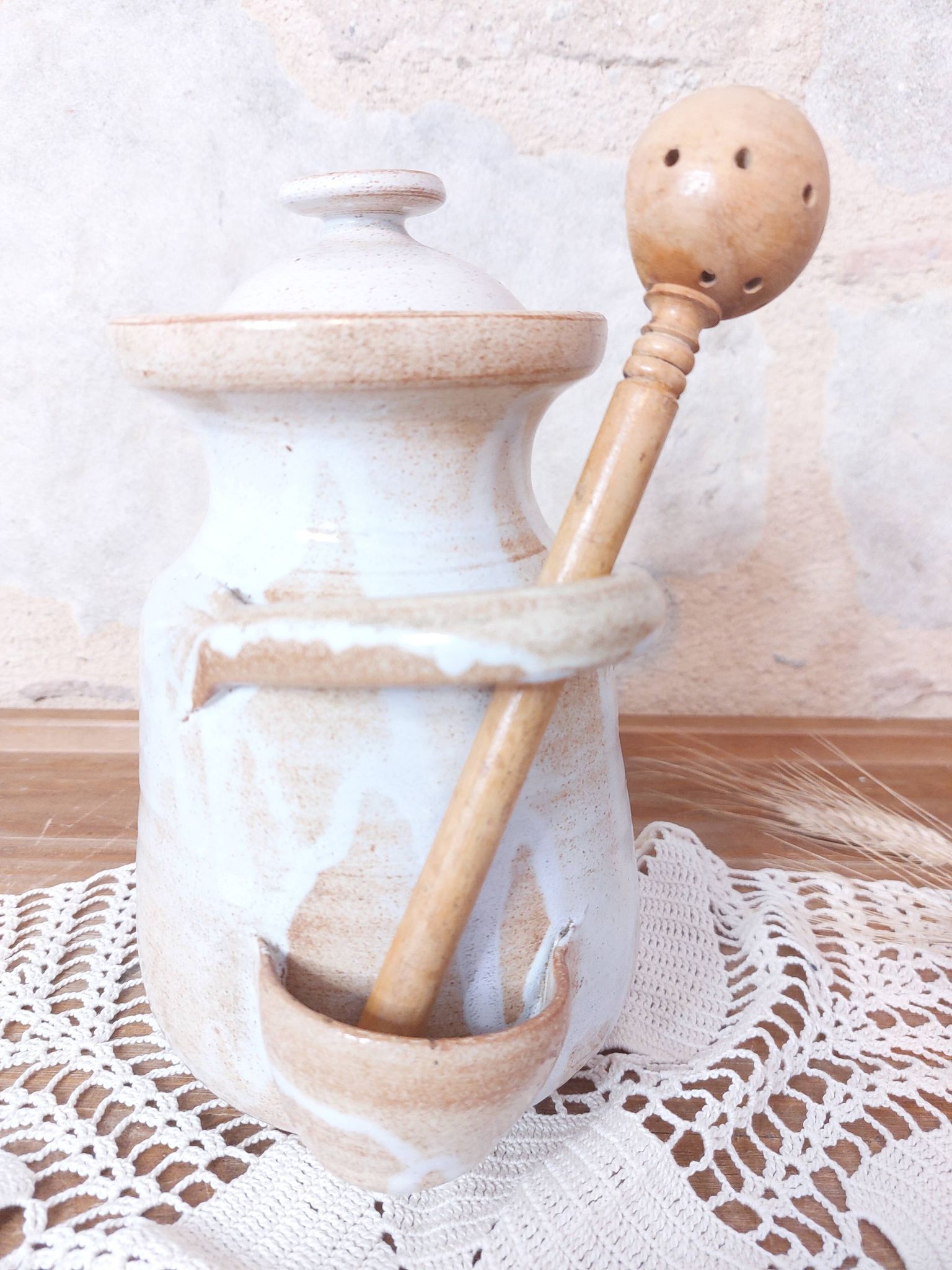 Old large vintage stoneware olive pot with its wooden spoon