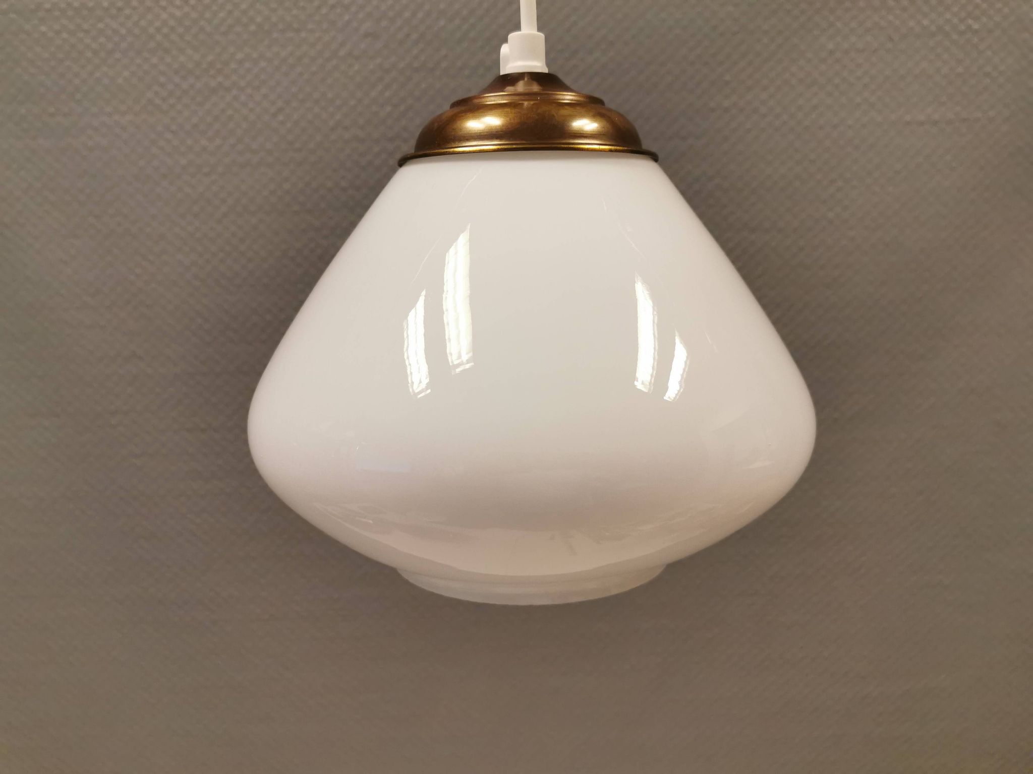 Beautiful ball-shaped hanging lamp in white opal glass with brass top.