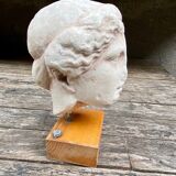 Tête en plâtre d’une déesse antique sur son socle en bois