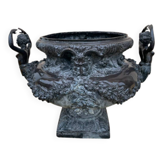 Cast iron vase decorated with mermaids.