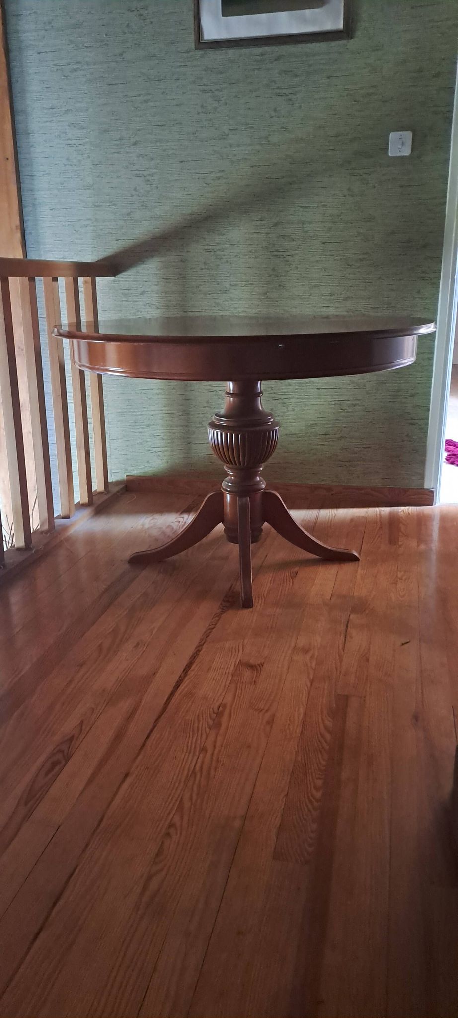 Round solid walnut table with central leg from the 1950s with extensions.