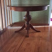 Round solid walnut table with central leg from the 1950s with extensions.