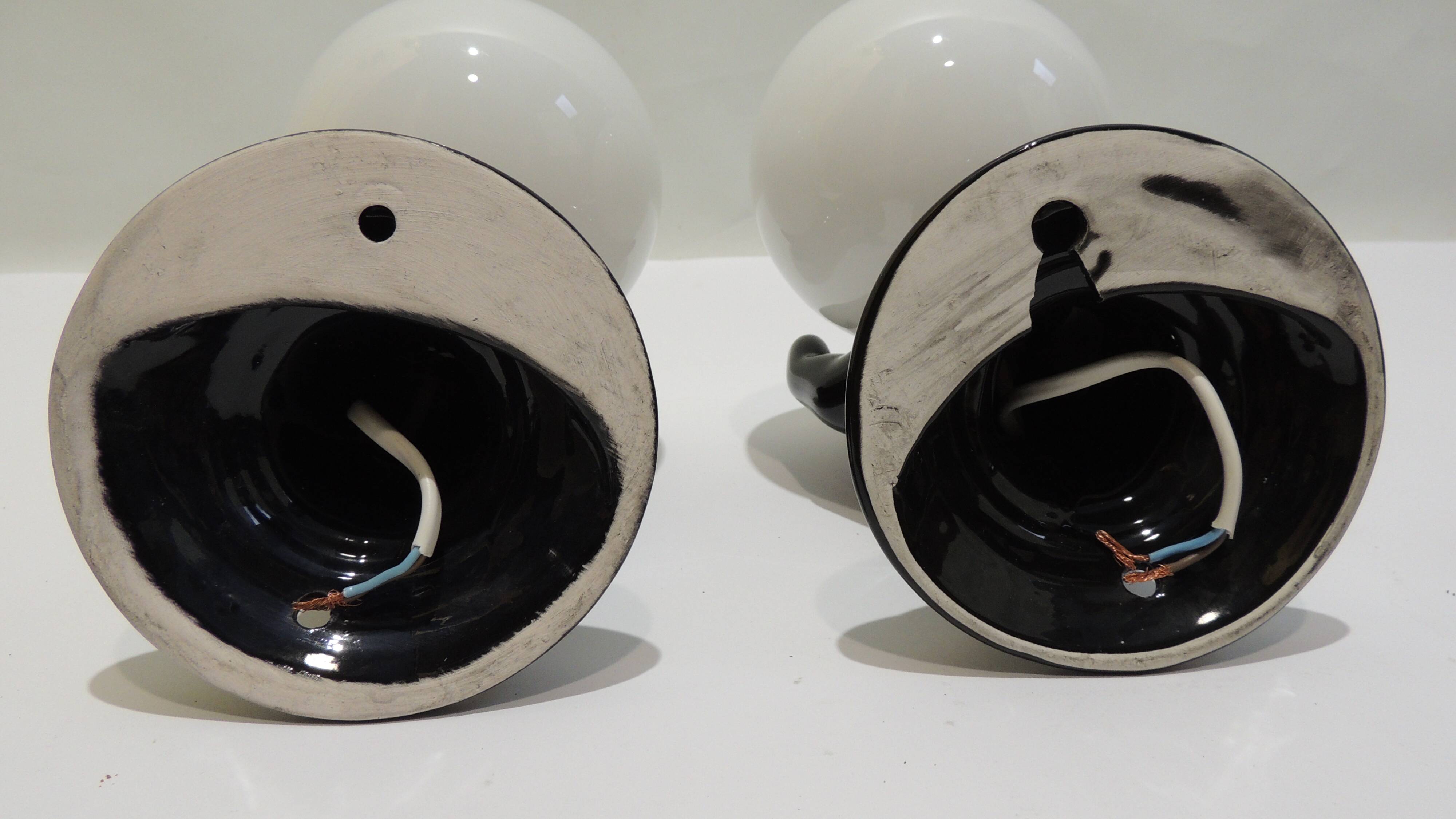 Paire d’appliques mains noires tenant un globe en opaline, années 70