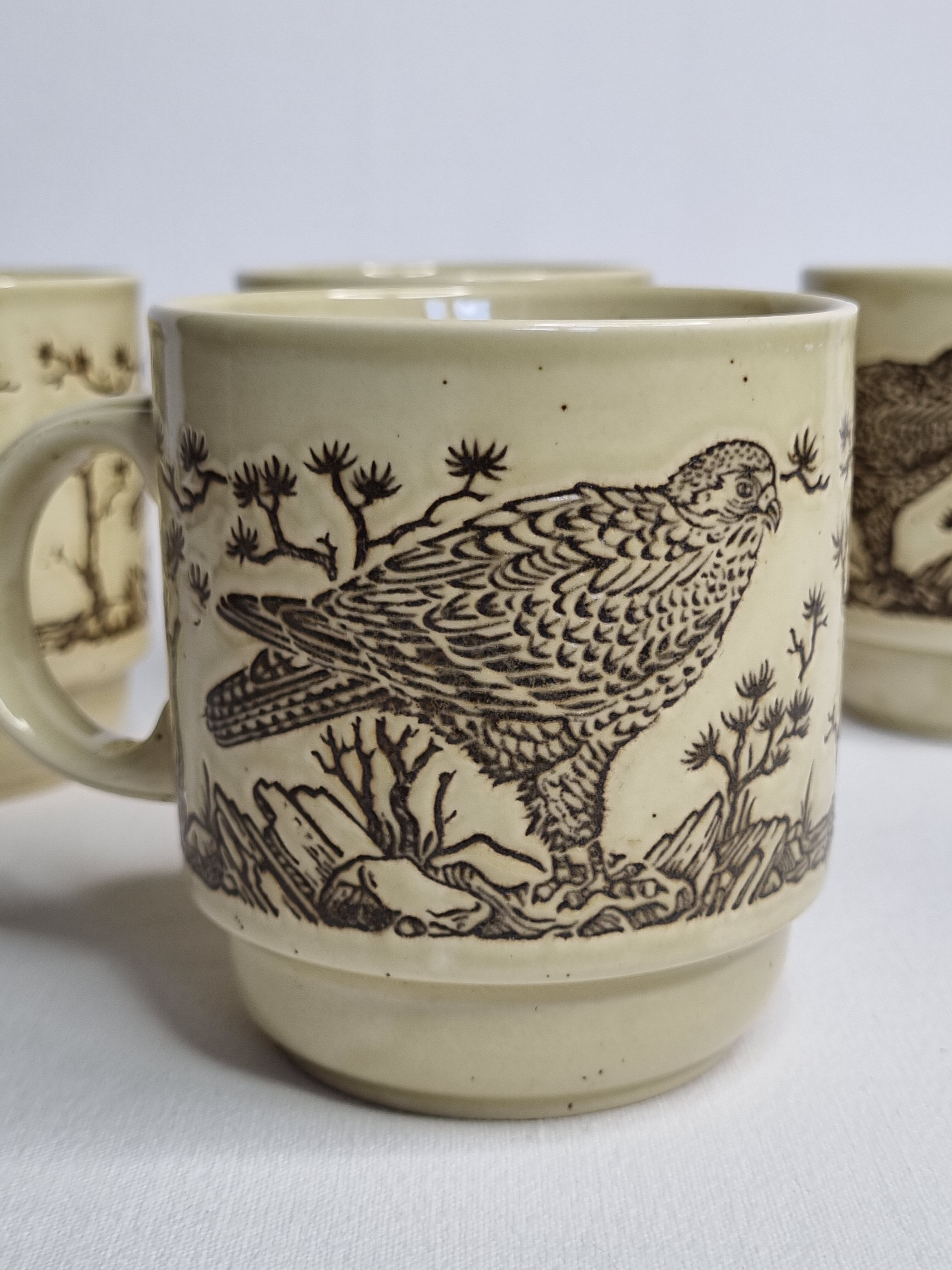 Set of four mugs in enamelled sandstone with bird decoration, made in england