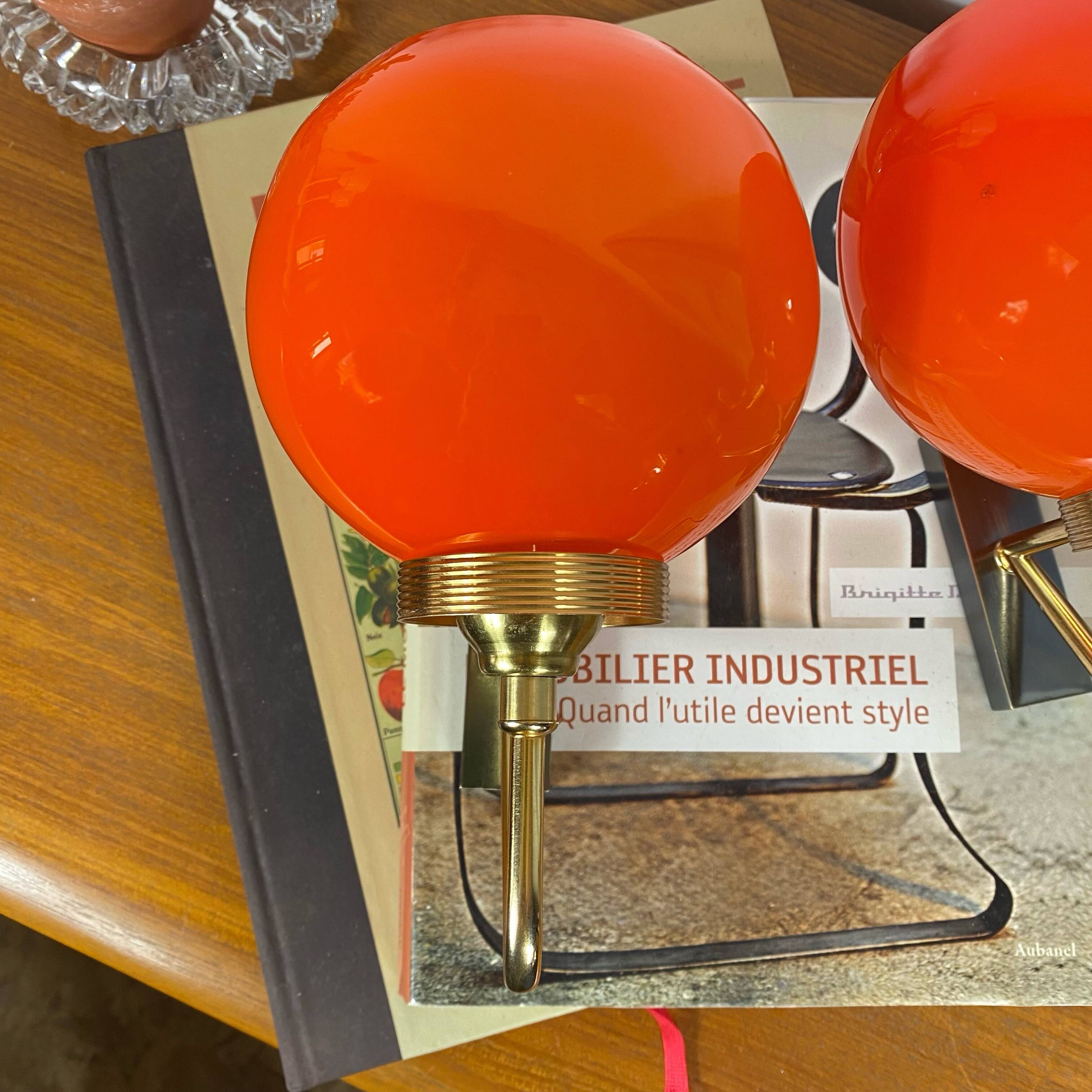 Pair of wall sconces with orange opaline globes and gold metal.