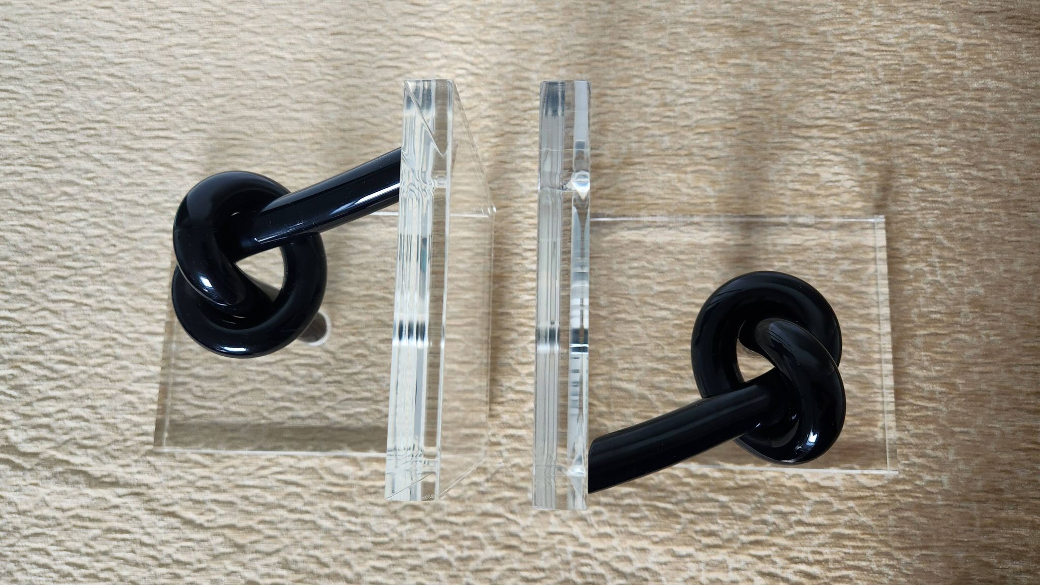 Bookends in plexiglass and knotted black tubes, 1980s design.