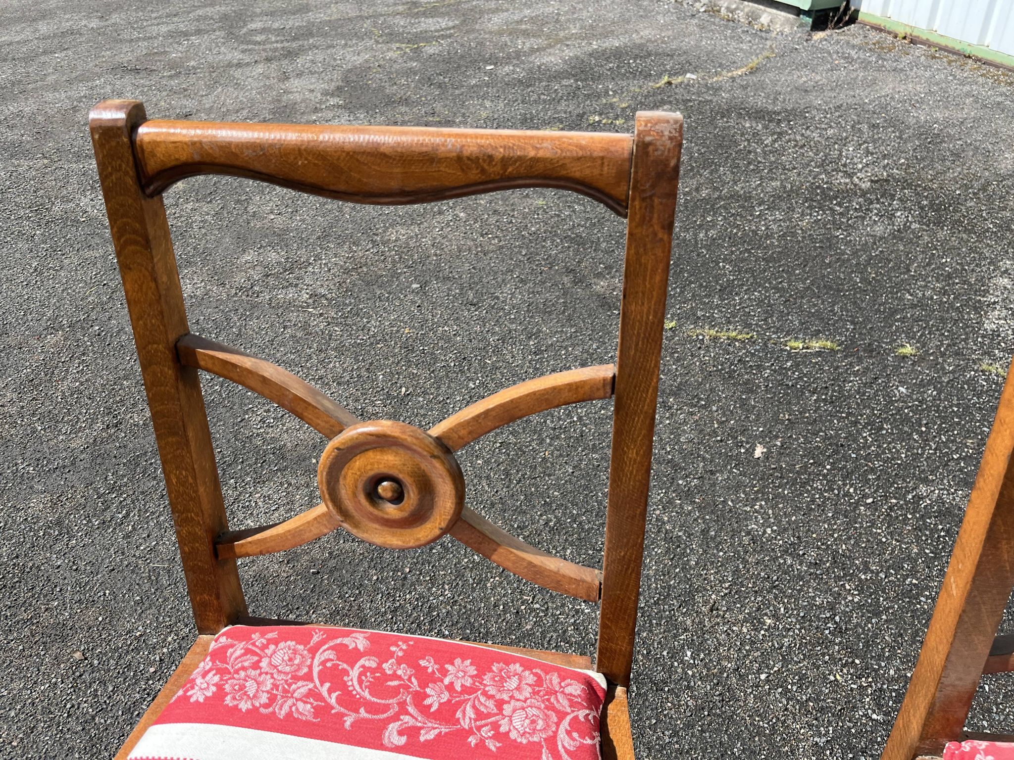 Pair of antique walnut chairs with rose design and red striped cushions.