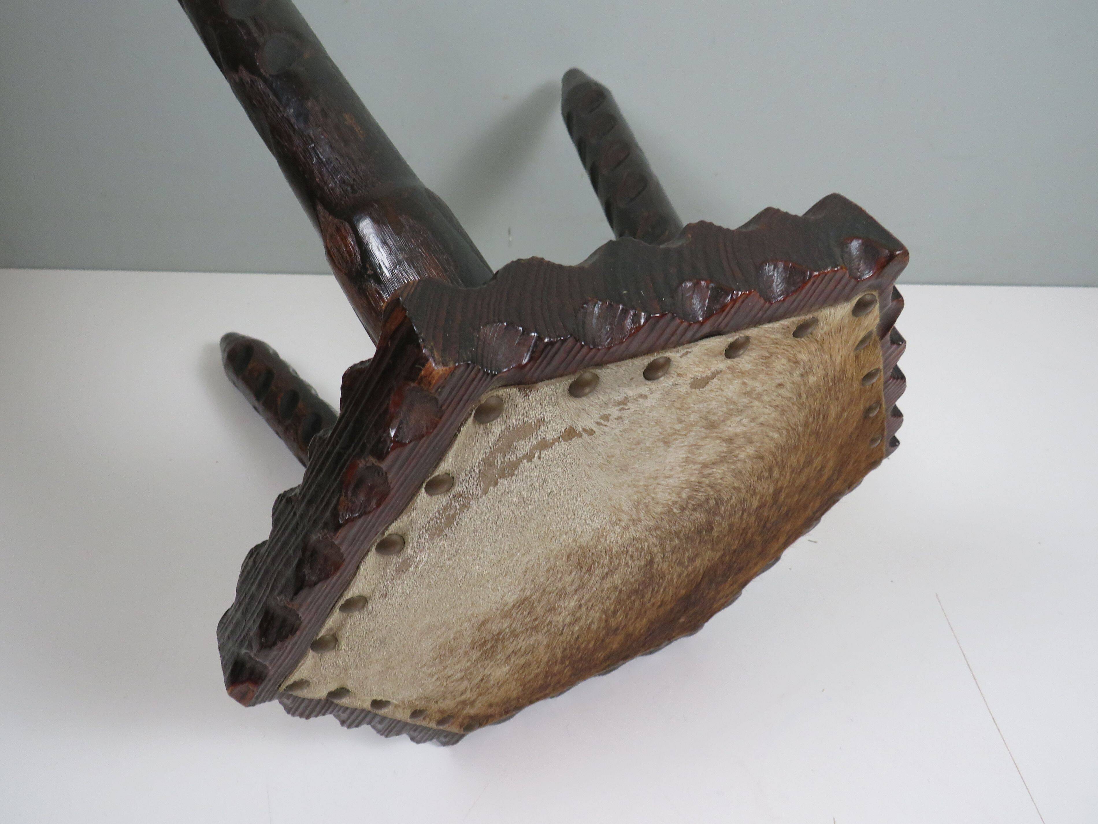 Vintage Spanish stool in carved wood with a leather seat.