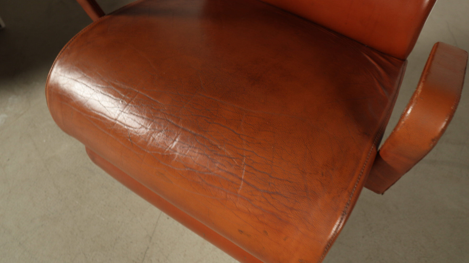 Pair of sculptural cognac leather armchairs, 1970s