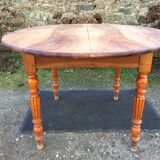 Table ovale ancienne en cerisier à piétement parapluie.