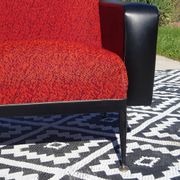Pair of vintage armchairs in black faux leather and red fabric.