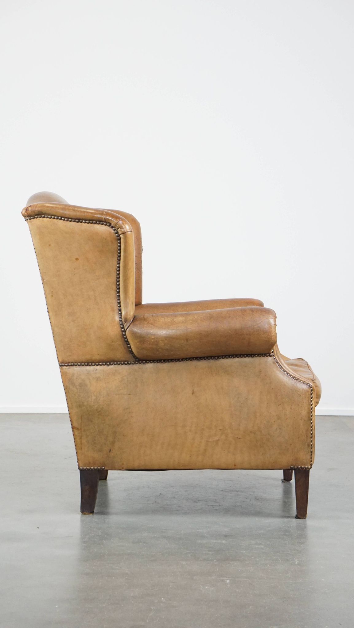 Patinated sheep leather wingback armchair