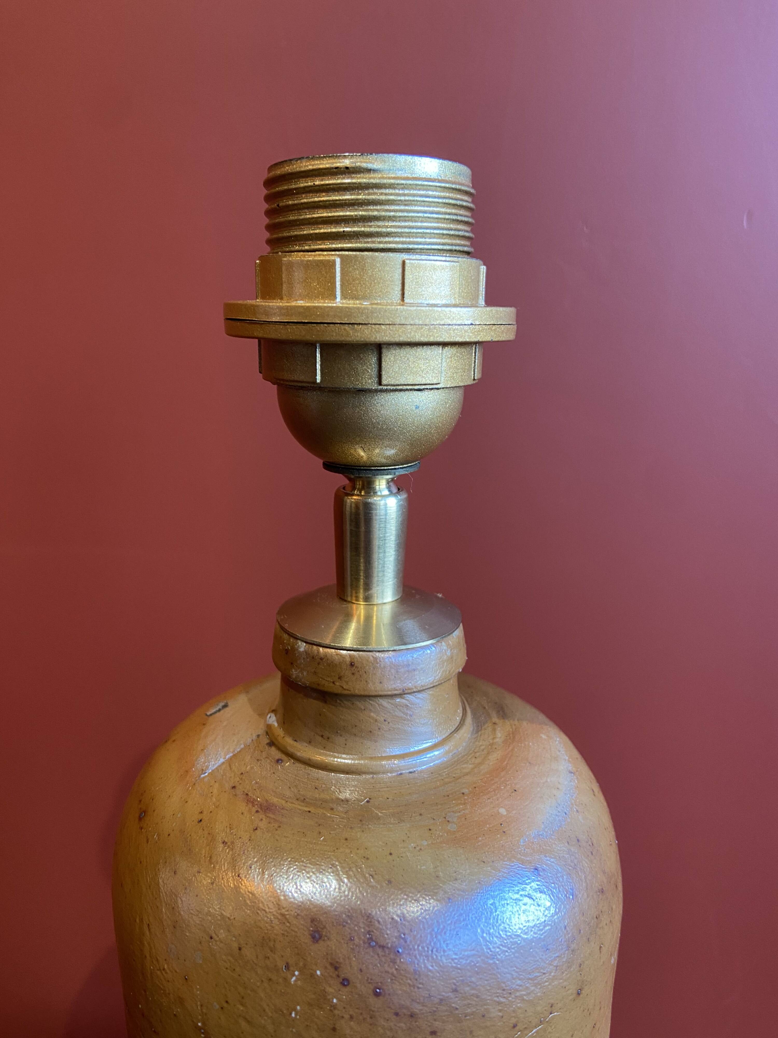 "Stoneware Bottle Lamp" with a multicoloured blue lampshade handwoven in India.