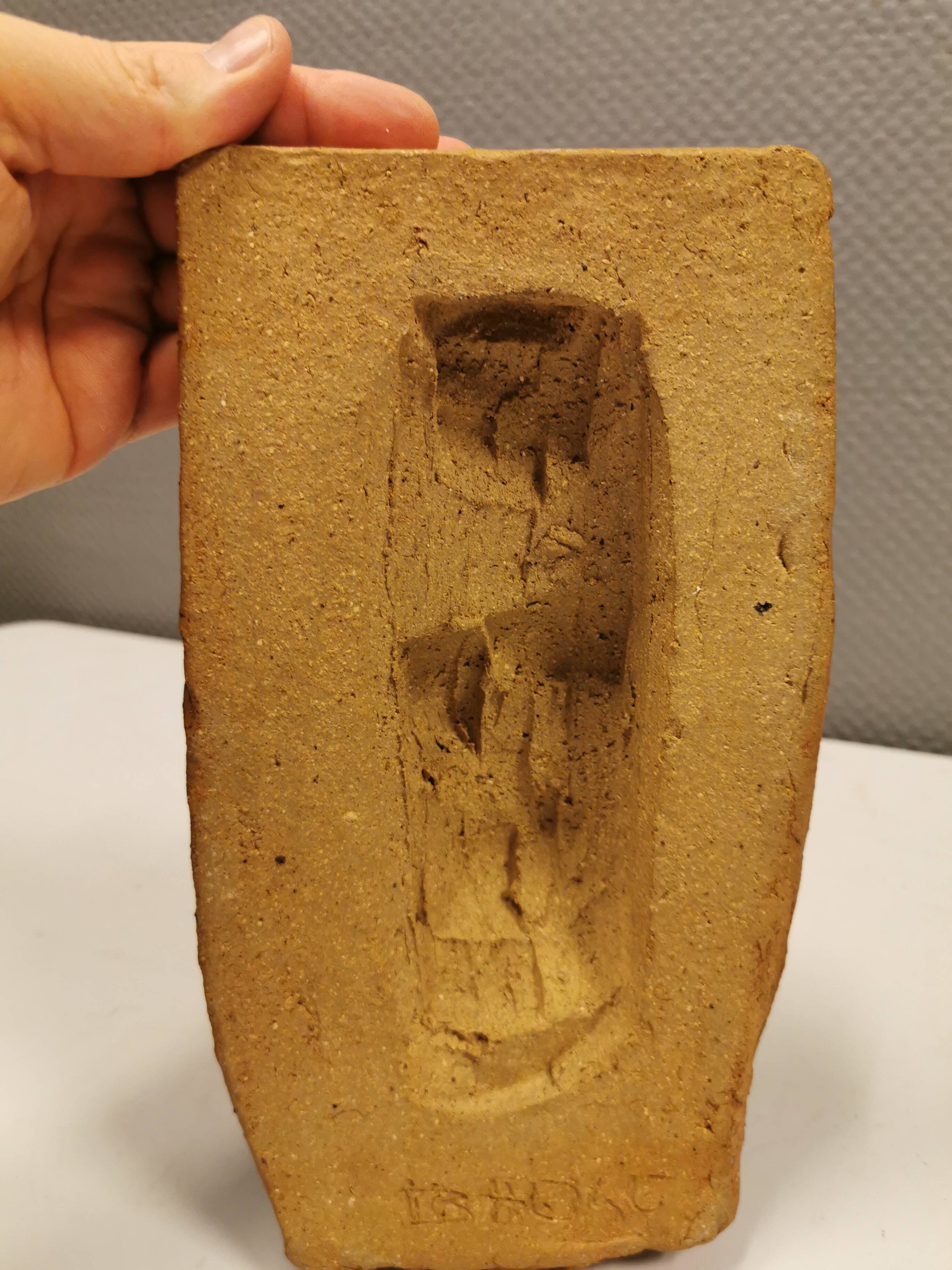 Ceramic relief portraying a lady. Emerging out of the background.