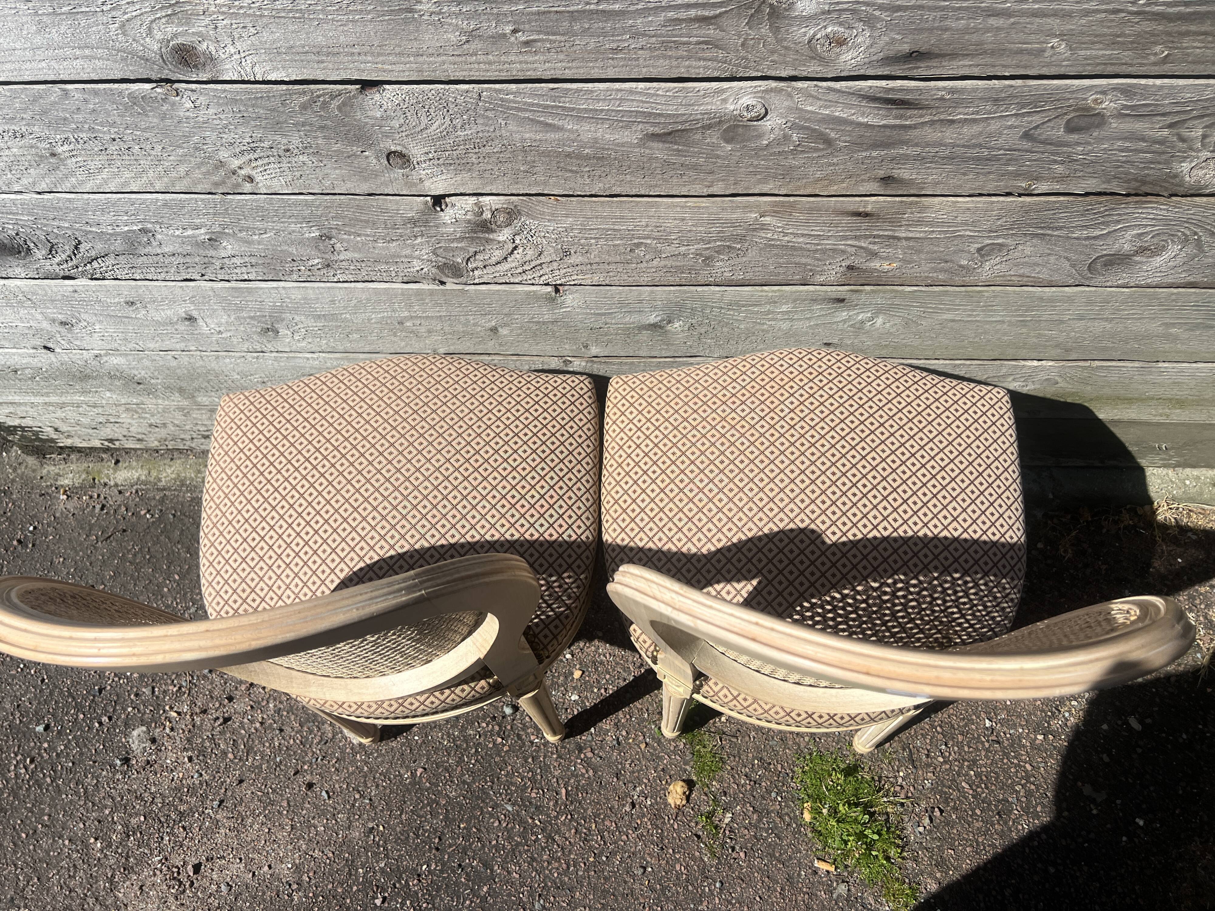 Pair of cerused chairs with fabric seats and caned backs.