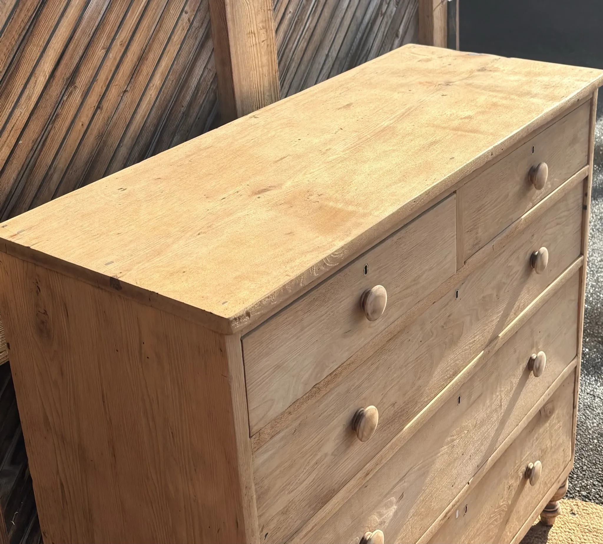 Large antique English chest of drawers in raw solid oak.